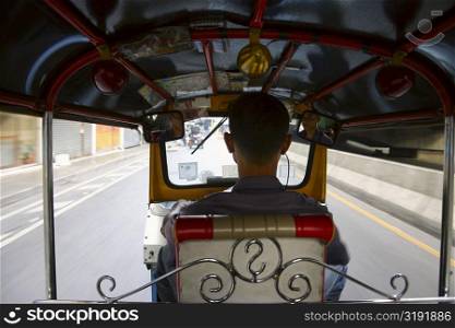 Rear view of a man driving a tuk-tuk, Bangkok, Thailand