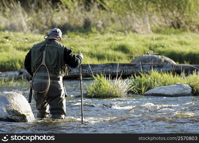 Rear view of a man fishing in the river