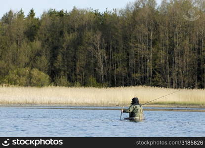 Rear view of a man fishing in the river