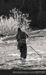Rear view of a man fishing in the river