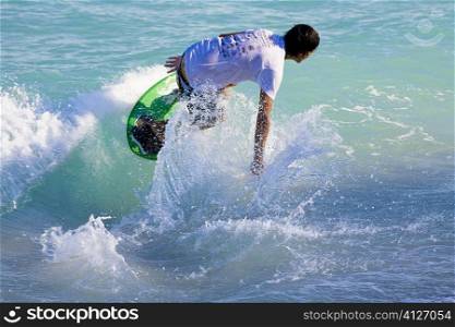 Rear view of a man on a surfboard, South Beach, Miami, Florida, USA