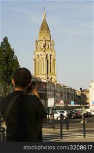 Rear view of a man photographing a church, Leglise Sainte-Marie De La Bastide, Bordeaux, Aquitaine, France