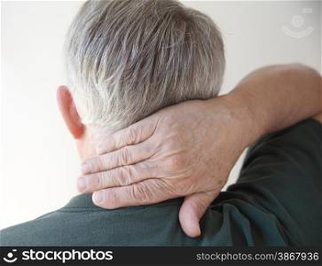 rear view of a man putting his hand on his aching neck