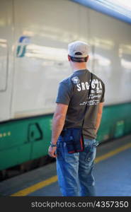 Rear view of a man standing at a railroad station, Rome, Italy