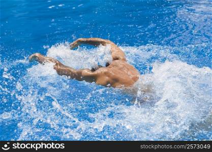 Rear view of a man swimming the butterfly stroke in a swimming pool