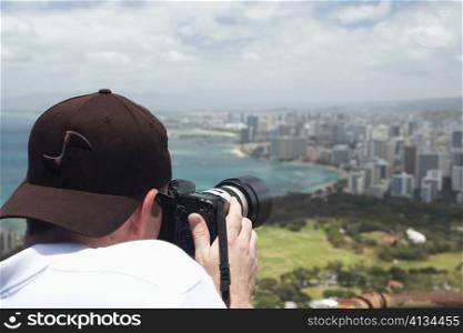 Rear view of a man taking a photograph, Diamond Head, Waikiki Beach, Honolulu, Oahu, Hawaii Islands, USA
