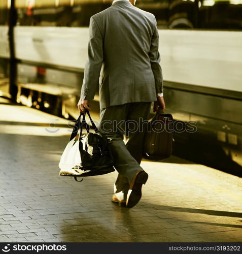 Rear view of a man walking at a railroad station platform, Rome, Italy