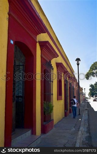 Rear view of a man walking on the sidewalk, Oaxaca, Oaxaca State, Mexico