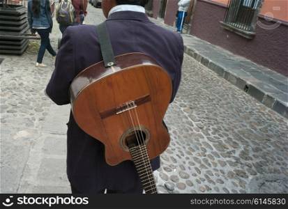 Rear view of a man with guitar on a street, San Miguel de Allende, Guanajuato, Mexico