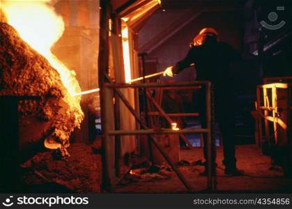 Rear view of a manual worker working in a steel mill