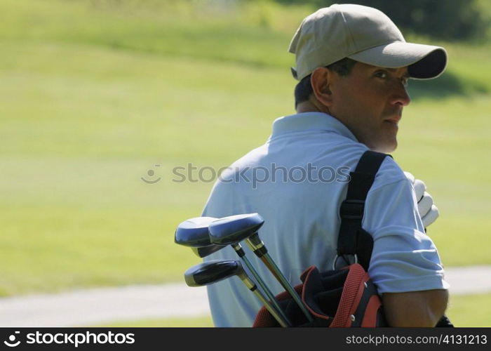 Rear view of a mature man carrying a golf bag