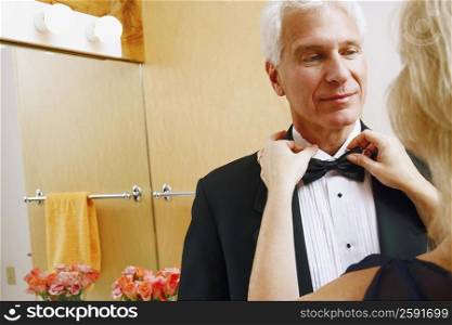 Rear view of a mature woman adjusting bow tie of a mature man