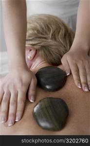 Rear view of a mature woman receiving a back massage from a massage therapist