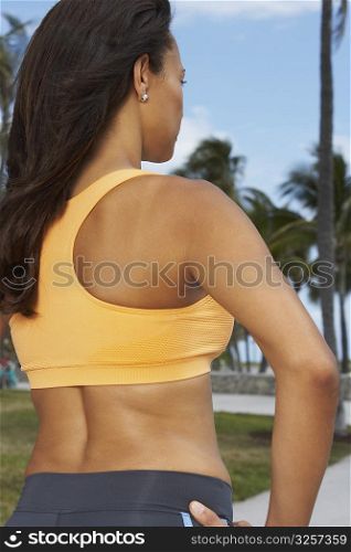 Rear view of a mature woman standing with arms akimbo, South Beach, Miami Beach, Florida, USA