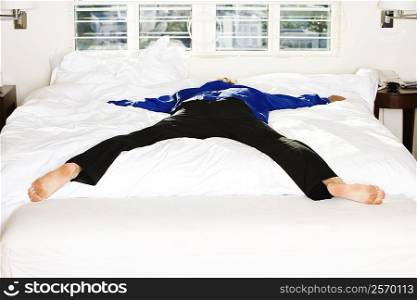 Rear view of a mid adult man lying on the bed