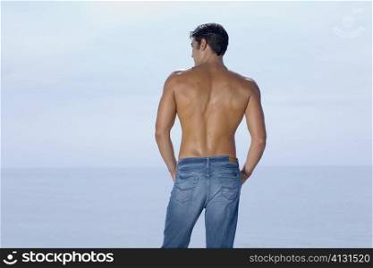 Rear view of a mid adult man standing on the beach