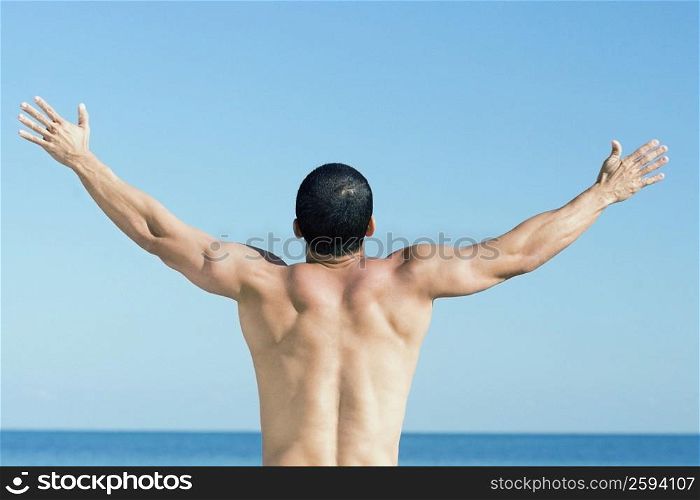 Rear view of a mid adult man with arm outstretched