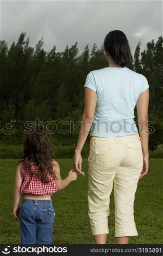 Rear view of a mother holding her daughter&acute;s hand