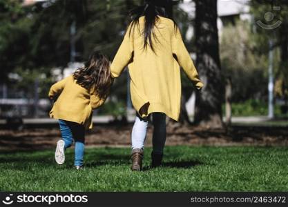 Rear view of a mother with her baby. Mom and daughter in an autumn park.