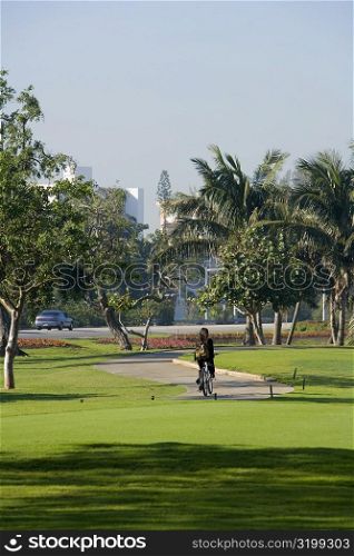 Rear view of a person cycling in a park, Miami, Florida, USA