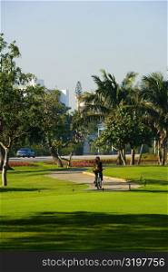 Rear view of a person cycling in the park, Miami, Florida, USA