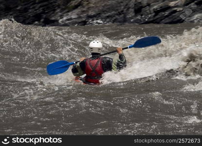 Rear view of a person kayaking in a river