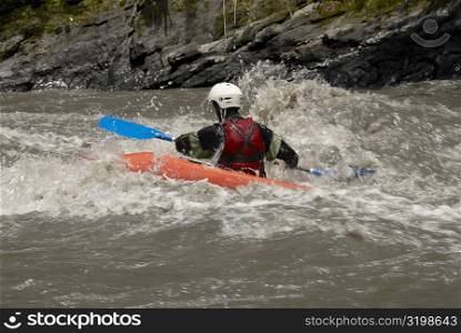 Rear view of a person kayaking in a river