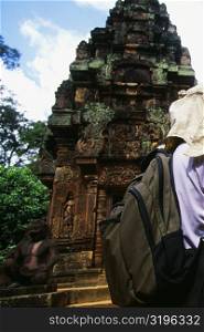 Rear view of a person standing in front of a temple, Banteay Srei, Angkor, Siem Reap, Cambodia