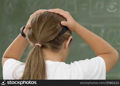 Rear view of a schoolgirl with her hands in her hair