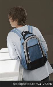 Rear view of a teenage boy carrying a backpack