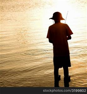 Rear view of a teenage boy fishing