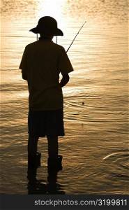 Rear view of a teenage boy fishing