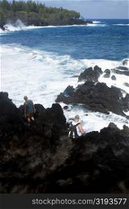 Rear view of a two people standing on a cliff, Kehena Beach, Big Island, Hawaii Islands, USA