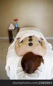 Rear view of a woman getting hot stone therapy