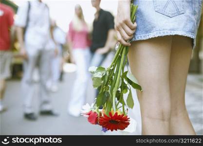 Rear view of a woman holding a bouquet of flowers