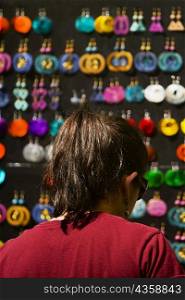 Rear view of a woman looking at earrings