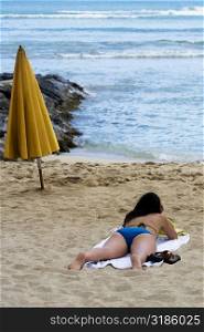 Rear view of a woman lying on the beach, Waikiki Beach, Honolulu, Oahu, Hawaii Islands, USA