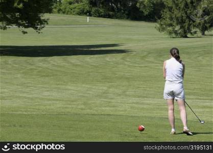 Rear view of a woman playing golf