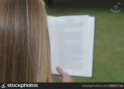 Rear view of a woman reading a book