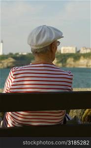Rear view of a woman sitting on a bench, Phare De Biarritz, Baie De Biarritz, Biarritz, France