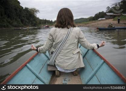 Rear View of a Woman sitting on boat in Nam Khan river, Luang Prabang, Laos
