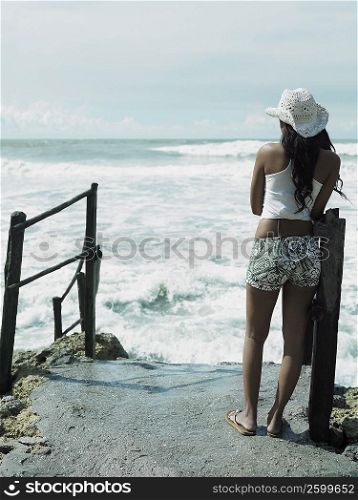 Rear view of a woman standing on a rock