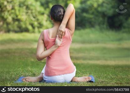 Rear view of a woman stretching her arms in a yoga