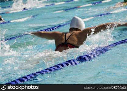 Rear view of a woman swimming in a swimming pool