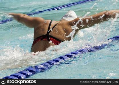 Rear view of a woman swimming in a swimming pool