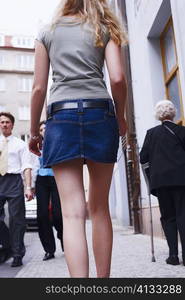 Rear view of a woman walking on the sidewalk