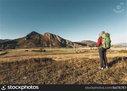Rear view of a woman with a backpack enjoying the view