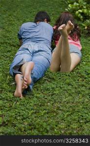 Rear view of a young couple lying in a park