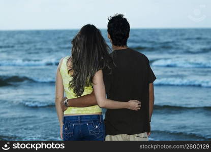 Rear view of a young couple standing on the beach