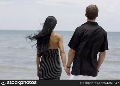 Rear view of a young couple standing on the beach